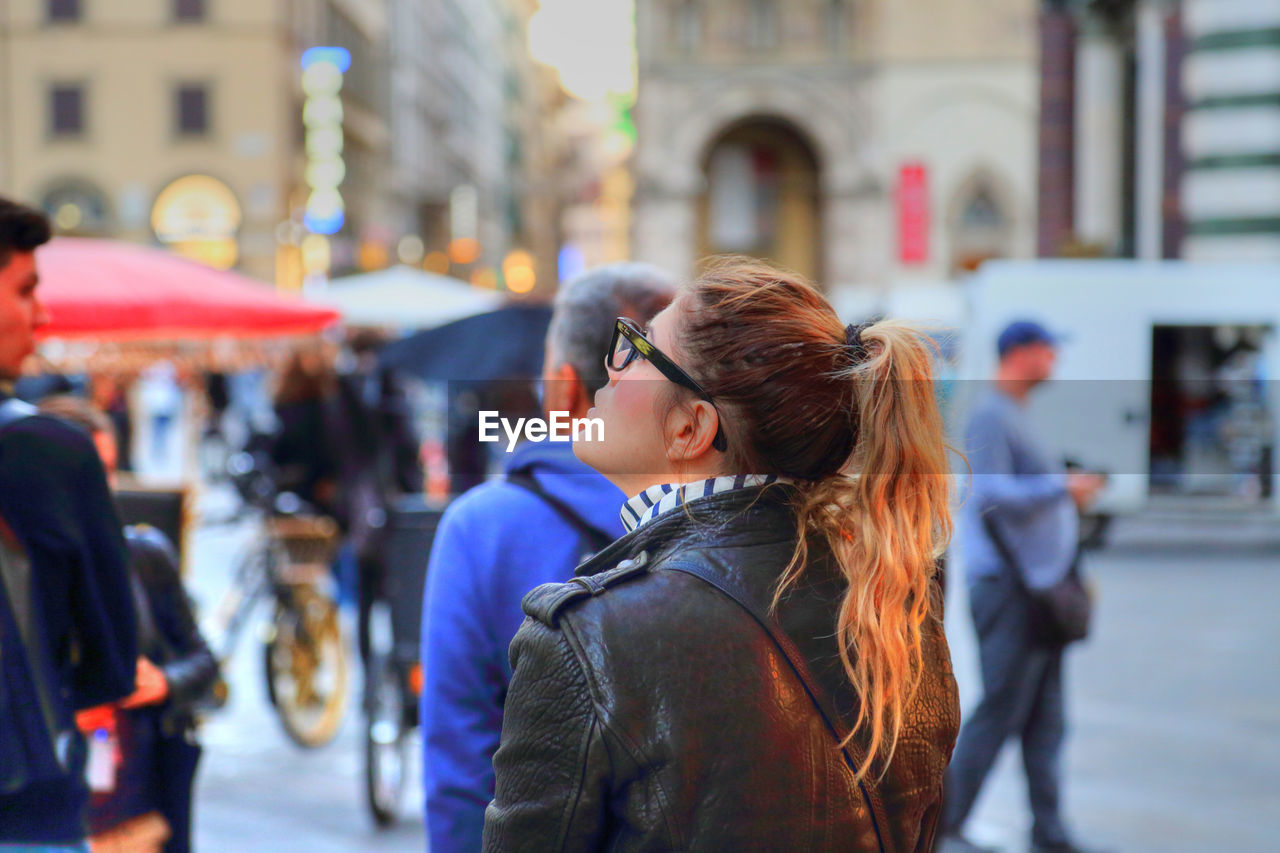 WOMAN LOOKING AT CITY STREET