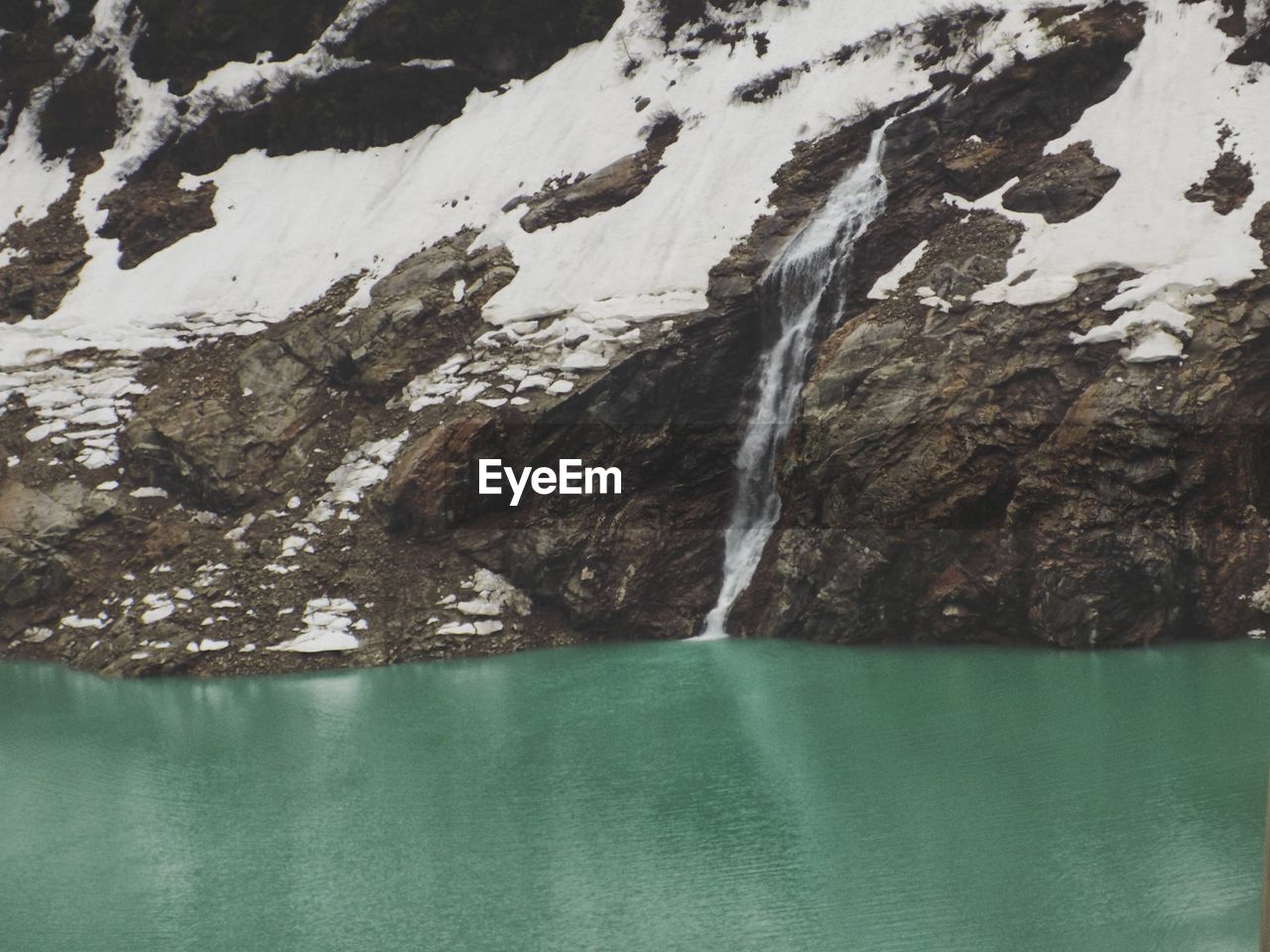 Scenic view of lake and snow covered mountain during winter