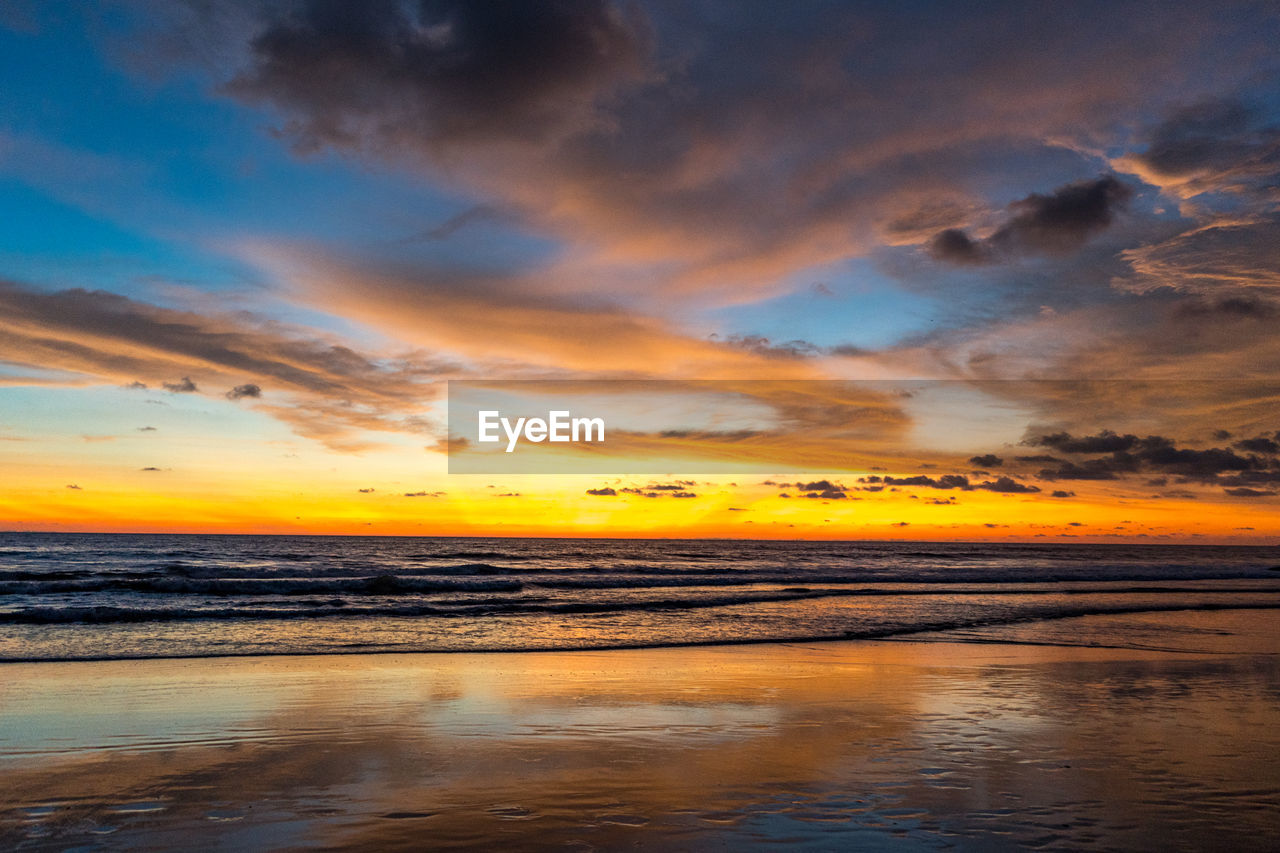 SCENIC VIEW OF BEACH AGAINST SKY DURING SUNSET