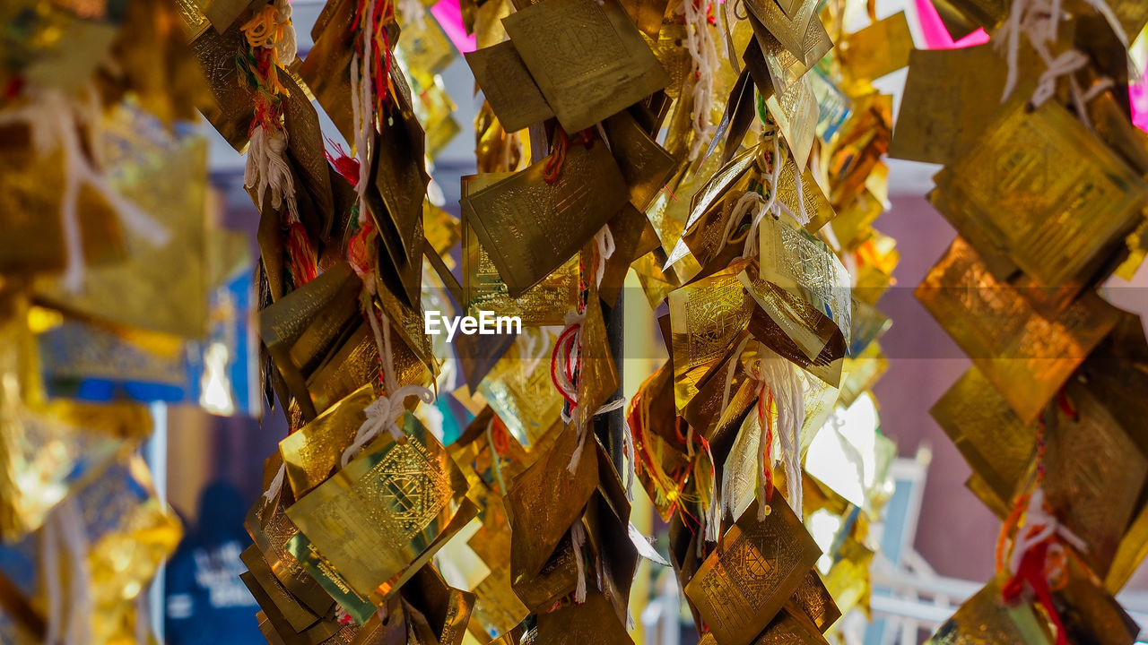 Close-up of gold colored papers hanging at temple