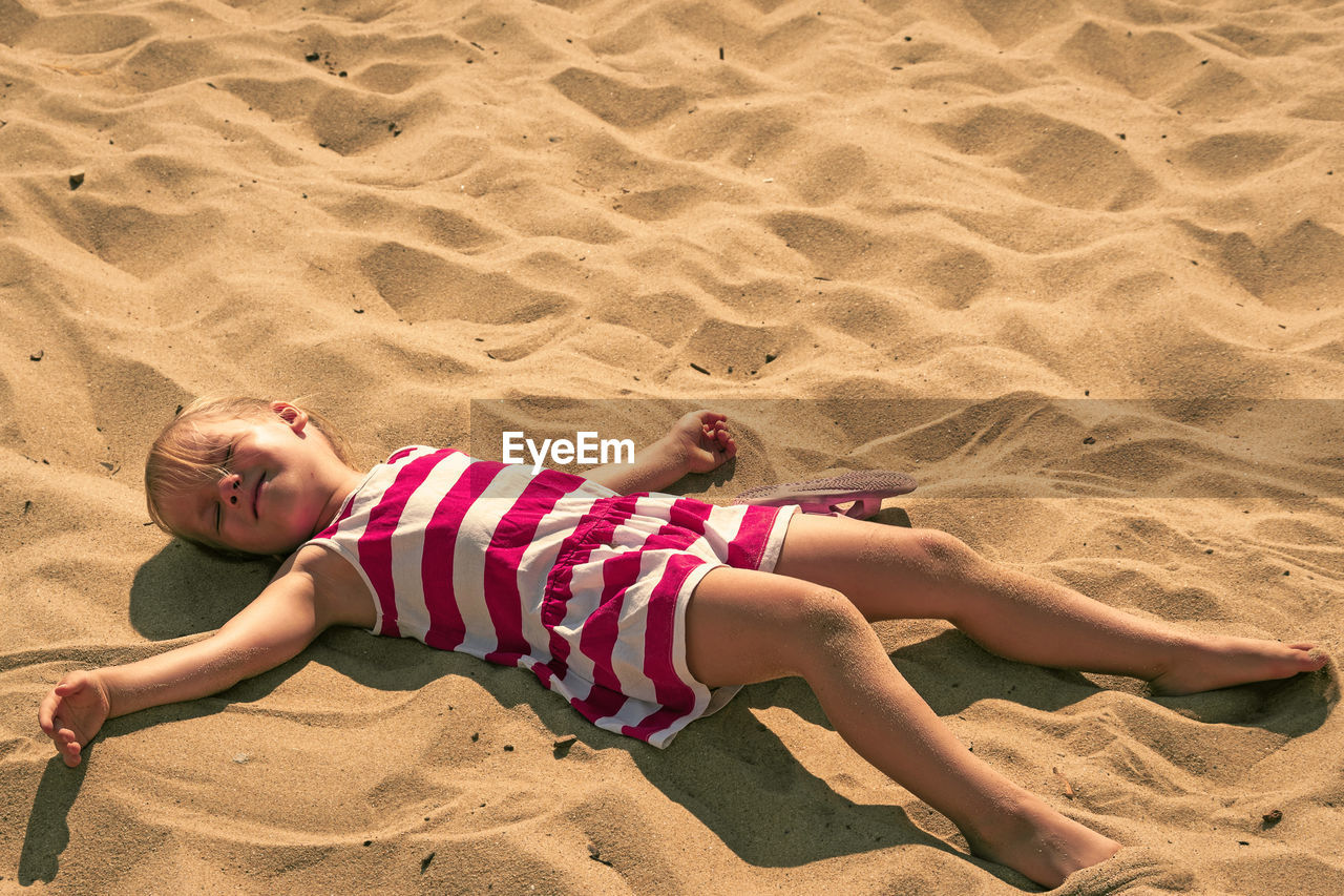 High angle view of girl lying on sand