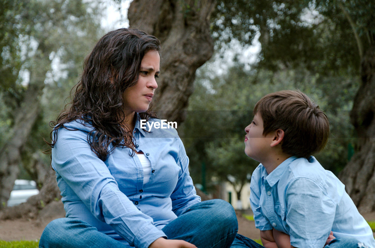 MOTHER AND DAUGHTER SITTING ON TREE