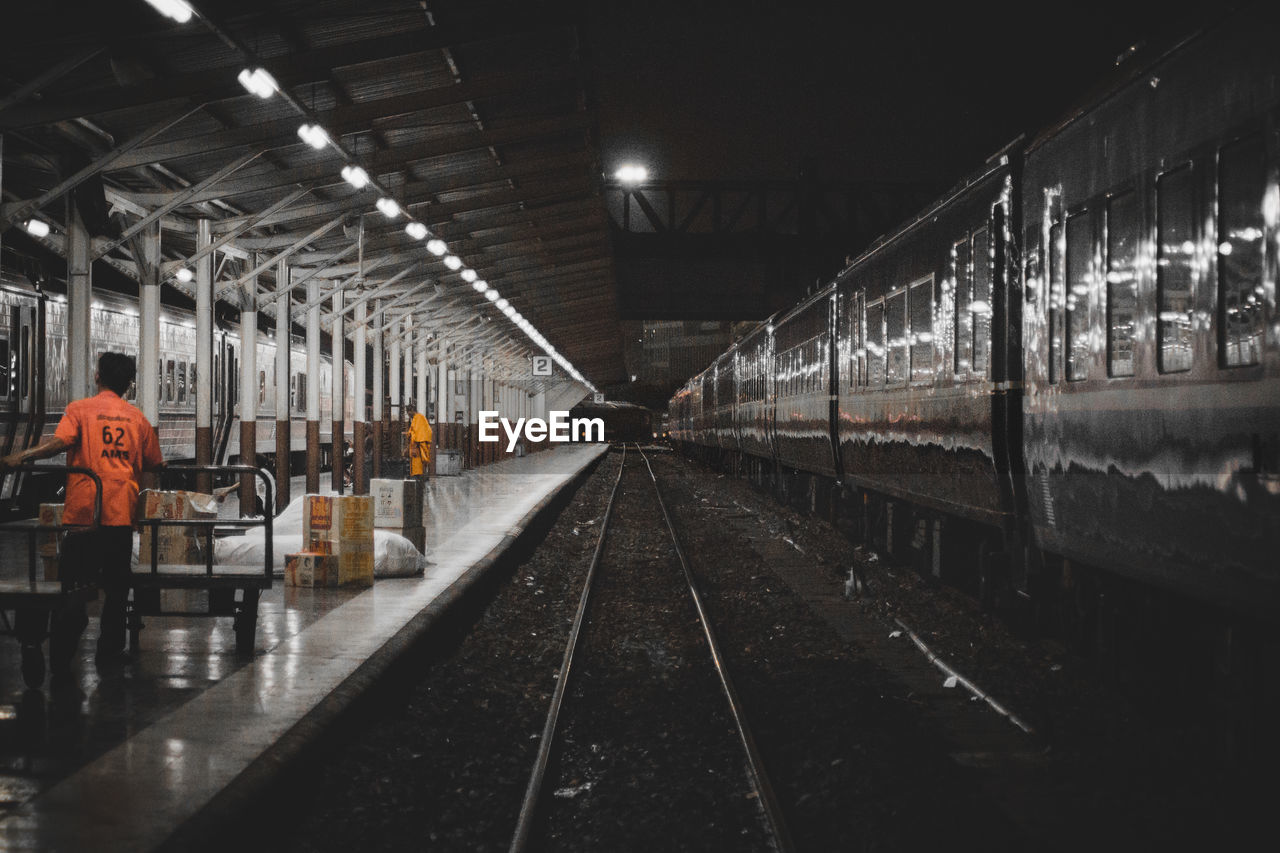 TRAIN ON RAILROAD STATION PLATFORM AT NIGHT