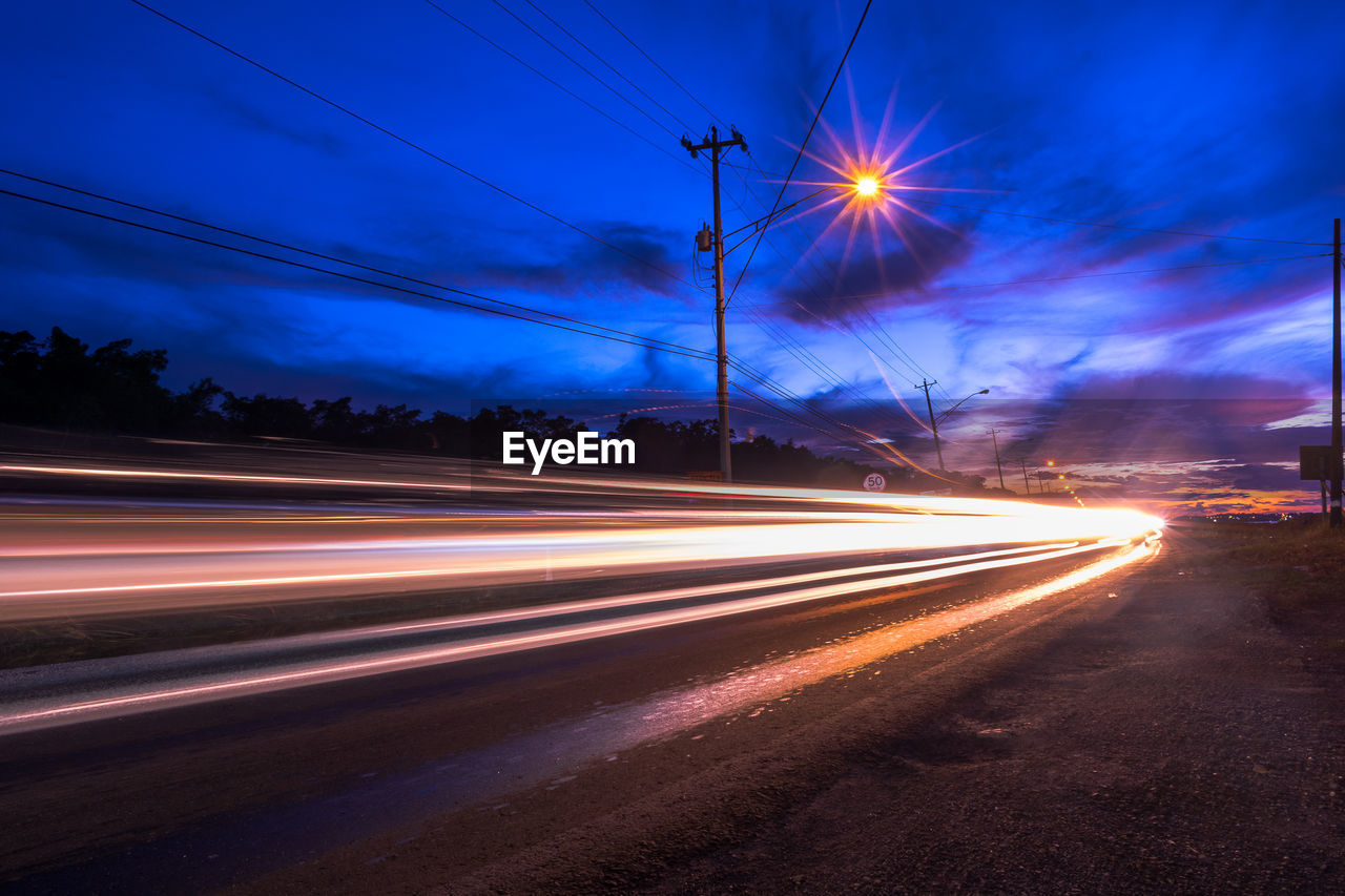 LIGHT TRAILS ON STREET AT NIGHT