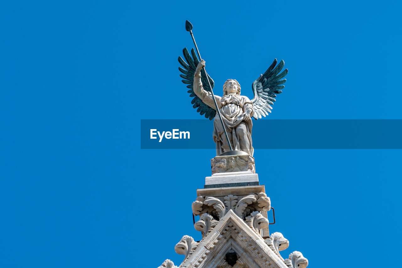 Low angle view of statue against blue sky