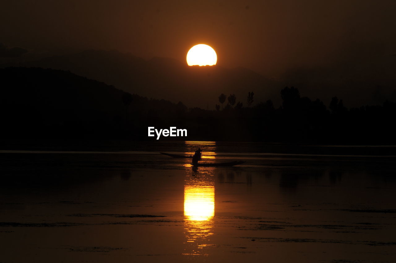 SCENIC VIEW OF LAKE AGAINST SKY AT SUNSET