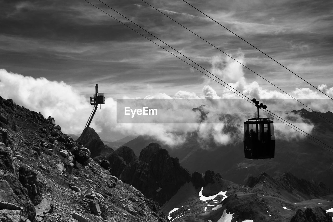 LOW ANGLE VIEW OF OVERHEAD CABLE CARS AGAINST SKY