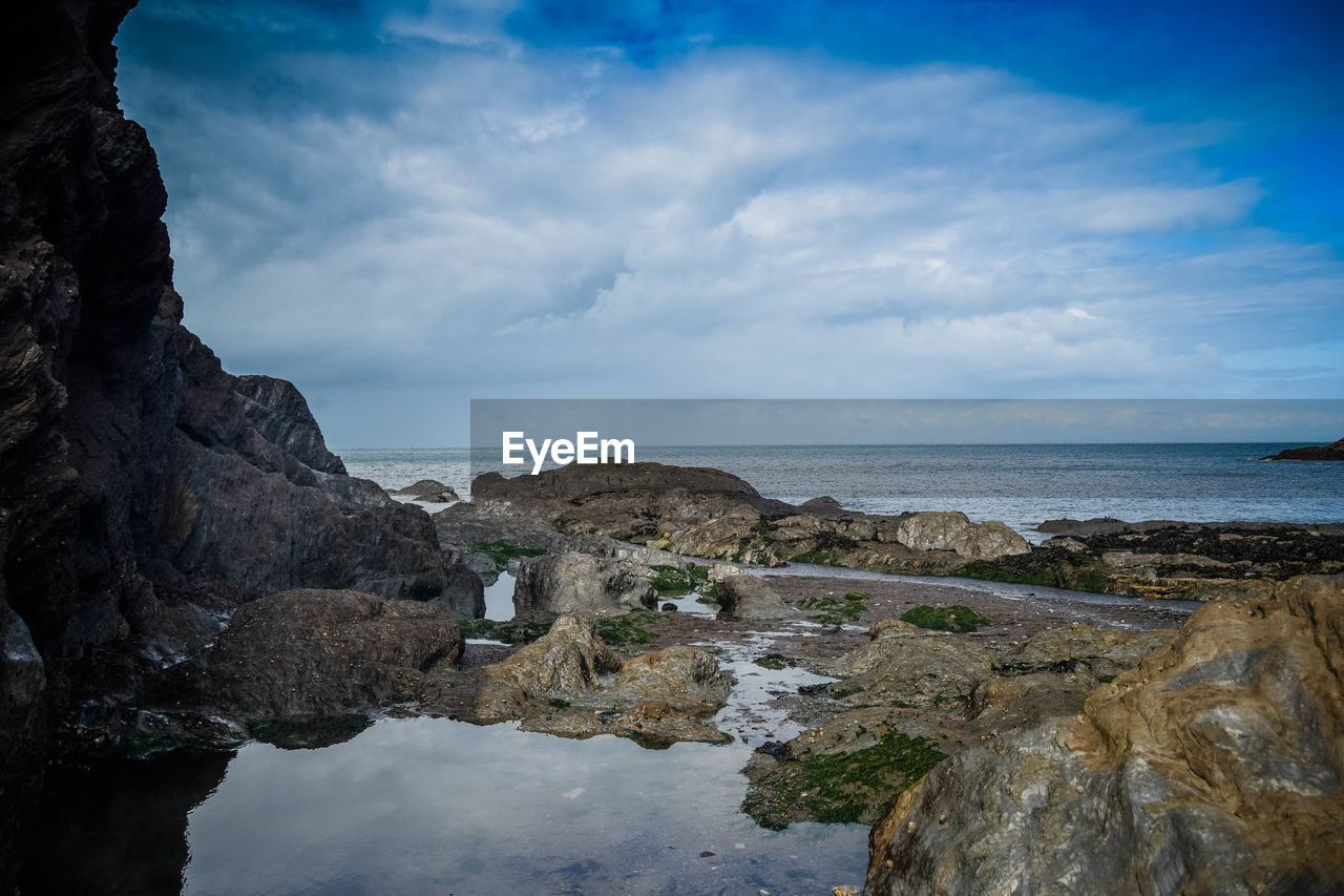 SCENIC VIEW OF SEA AGAINST ROCK FORMATION