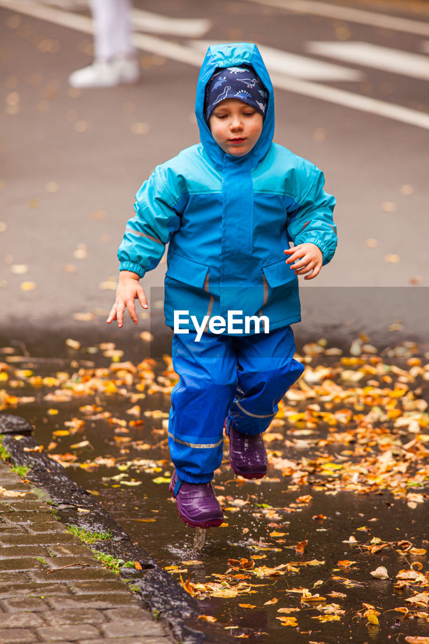 Full length of boy playing in puddle