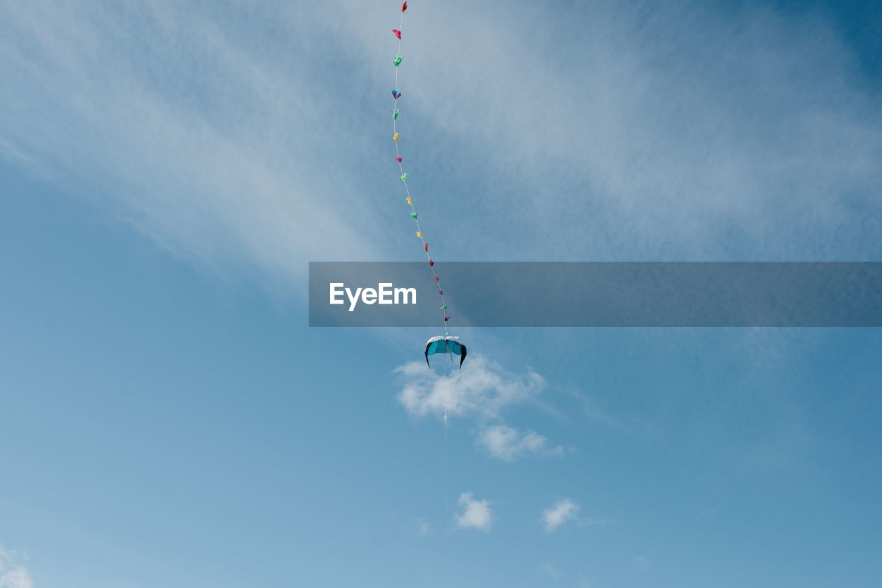 Colourful kite in the sky with fluffy clouds and blu skies