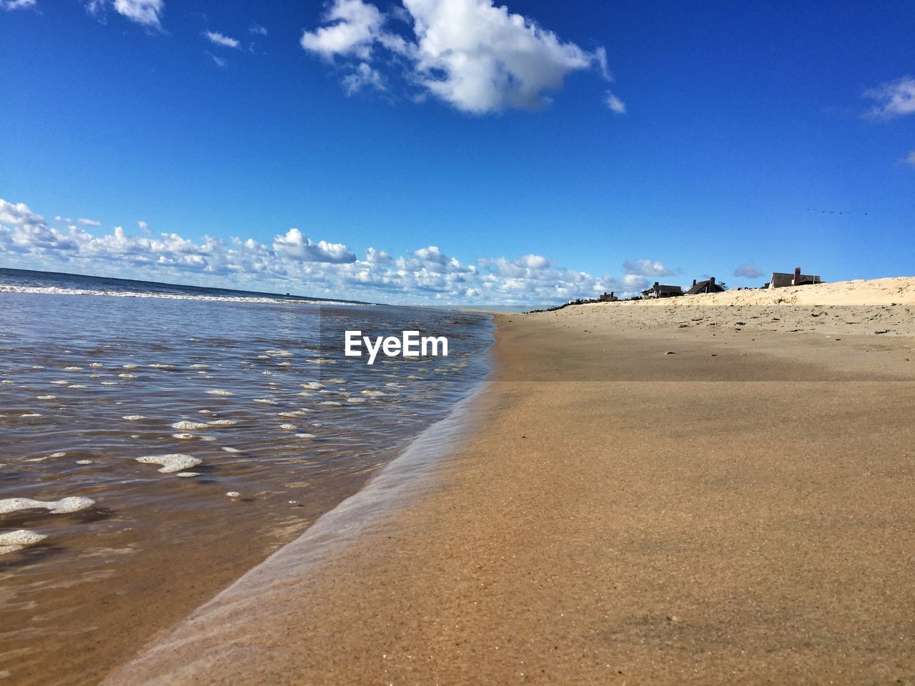 View of calm beach against blue sky