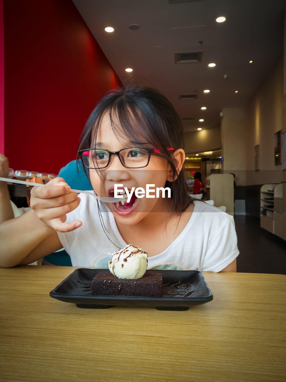 PORTRAIT OF YOUNG WOMAN SITTING AT RESTAURANT