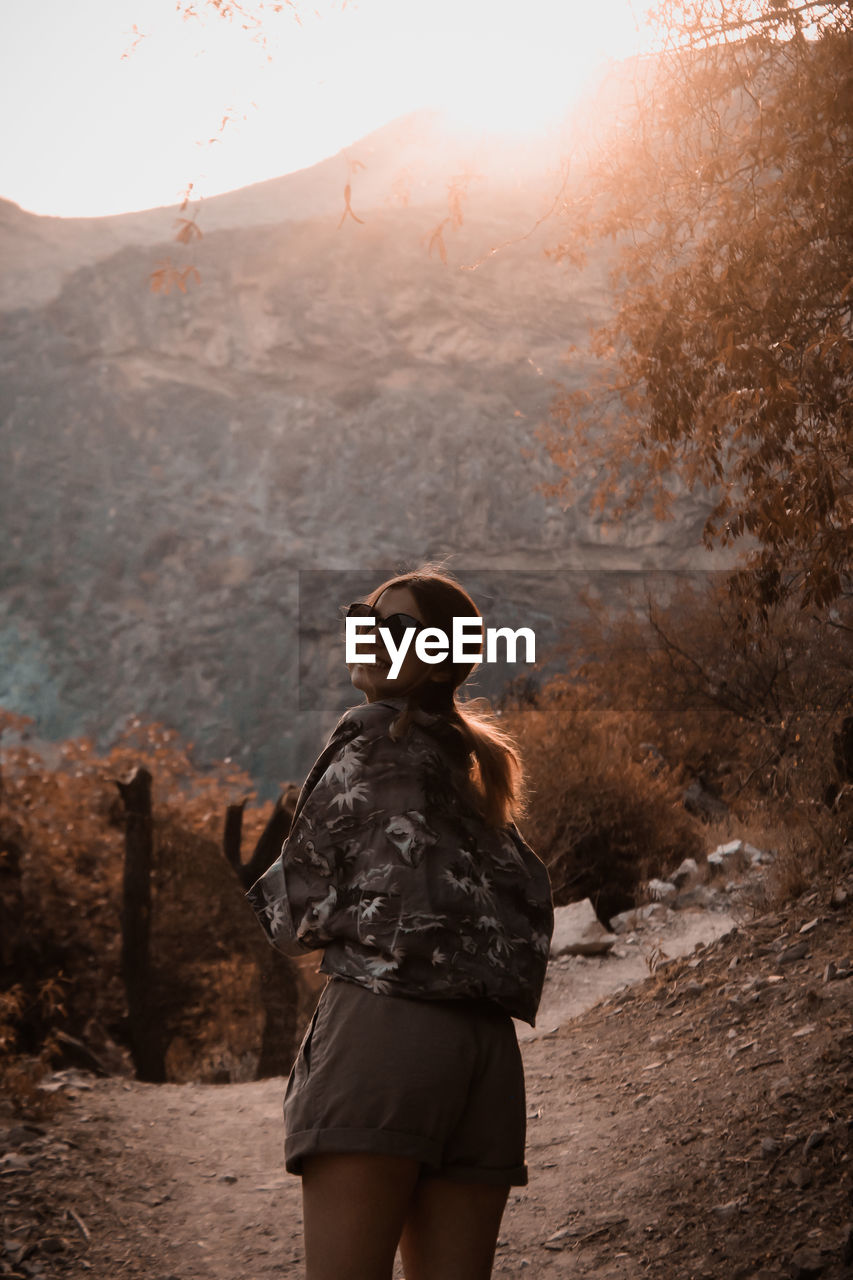 WOMAN STANDING ON MOUNTAIN