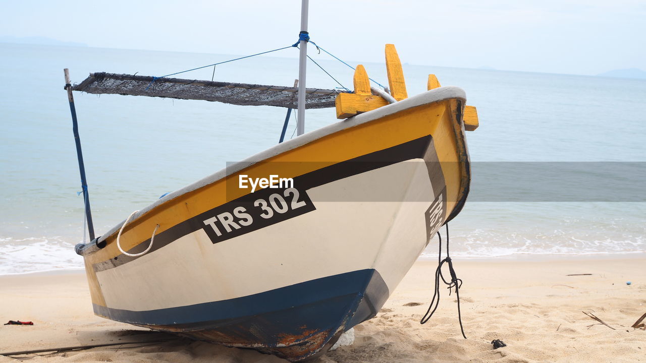 SHIP MOORED ON BEACH