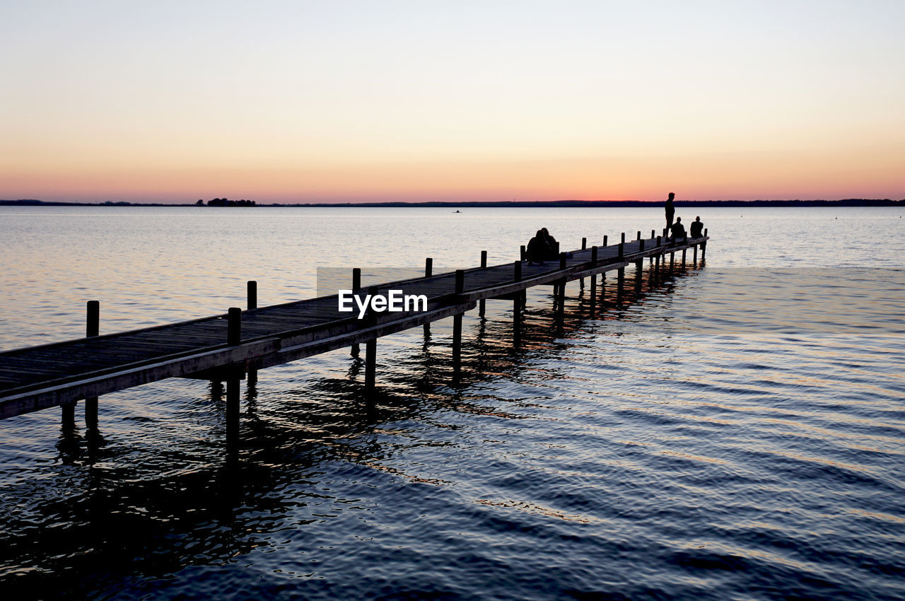 SILHOUETTE PIER OVER SEA AGAINST CLEAR SKY