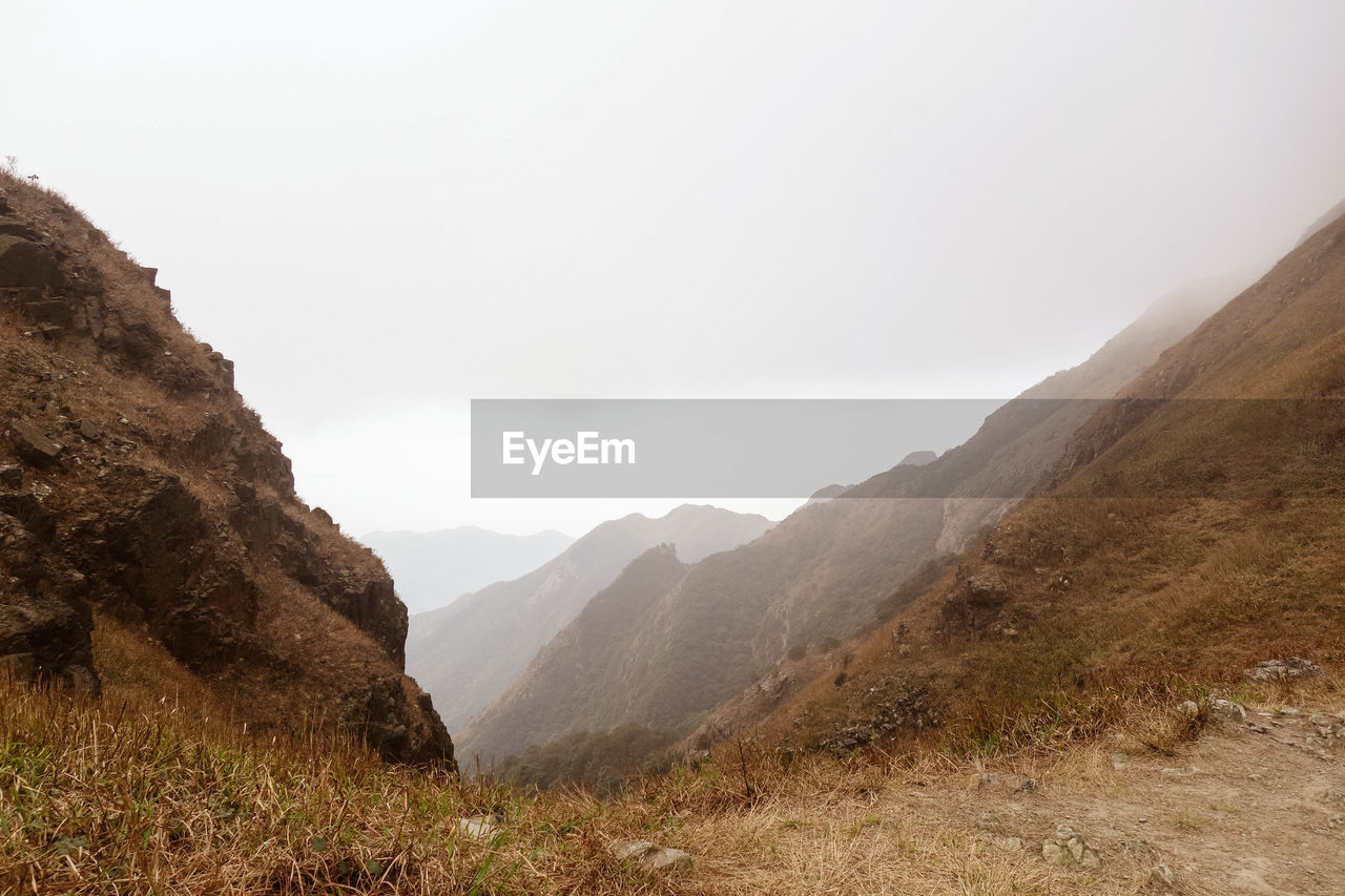 Scenic view of mountains against cloudy sky