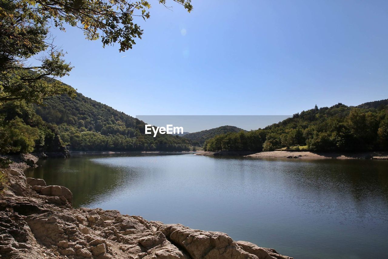 Scenic view of lake and mountains against clear sky