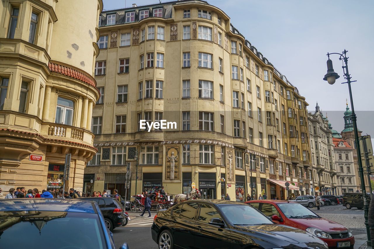 CARS ON ROAD AMIDST BUILDINGS IN CITY