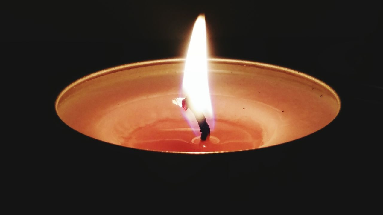 Close-up of illuminated diya against black background