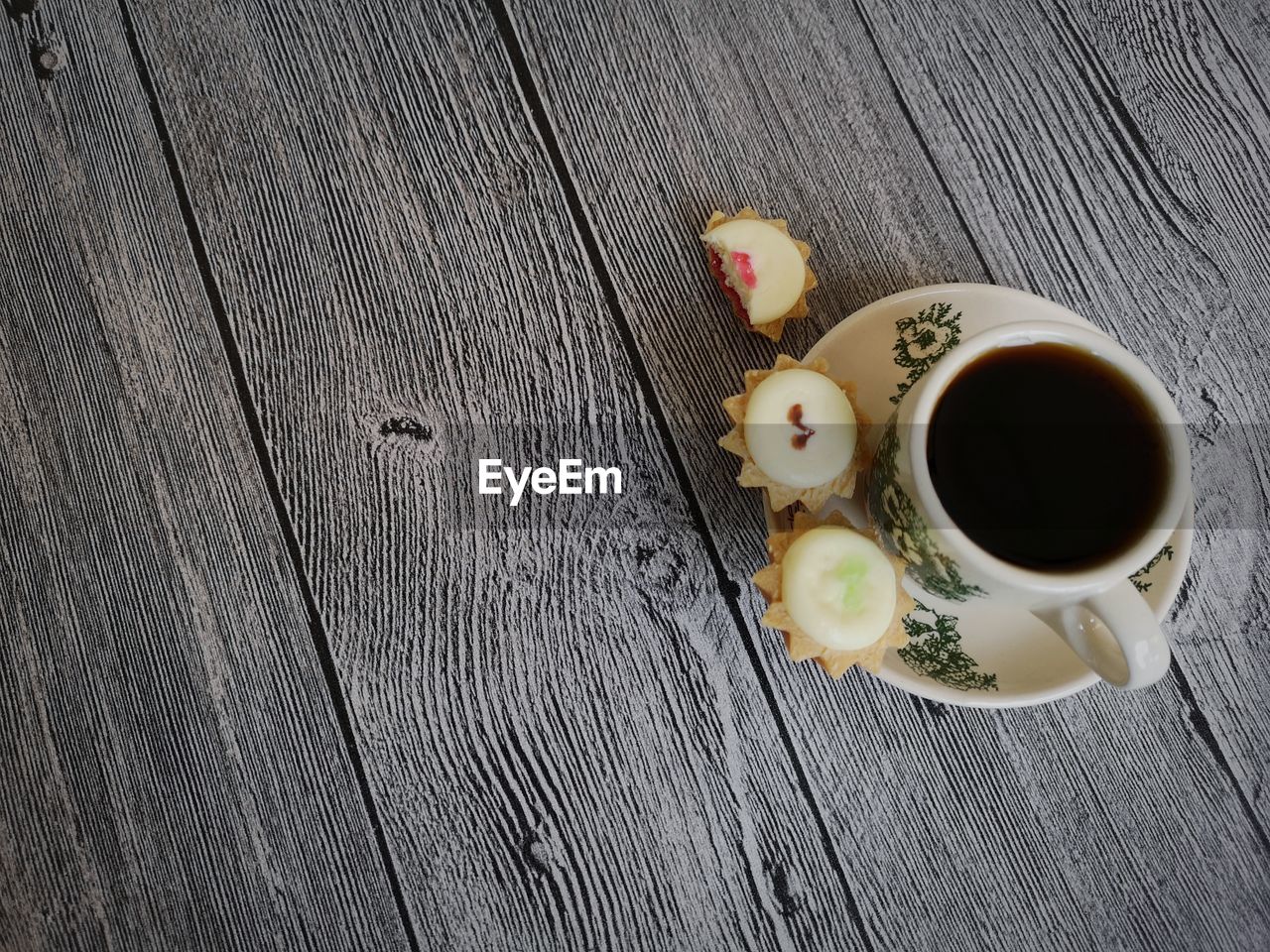 HIGH ANGLE VIEW OF COFFEE CUPS ON WOODEN TABLE