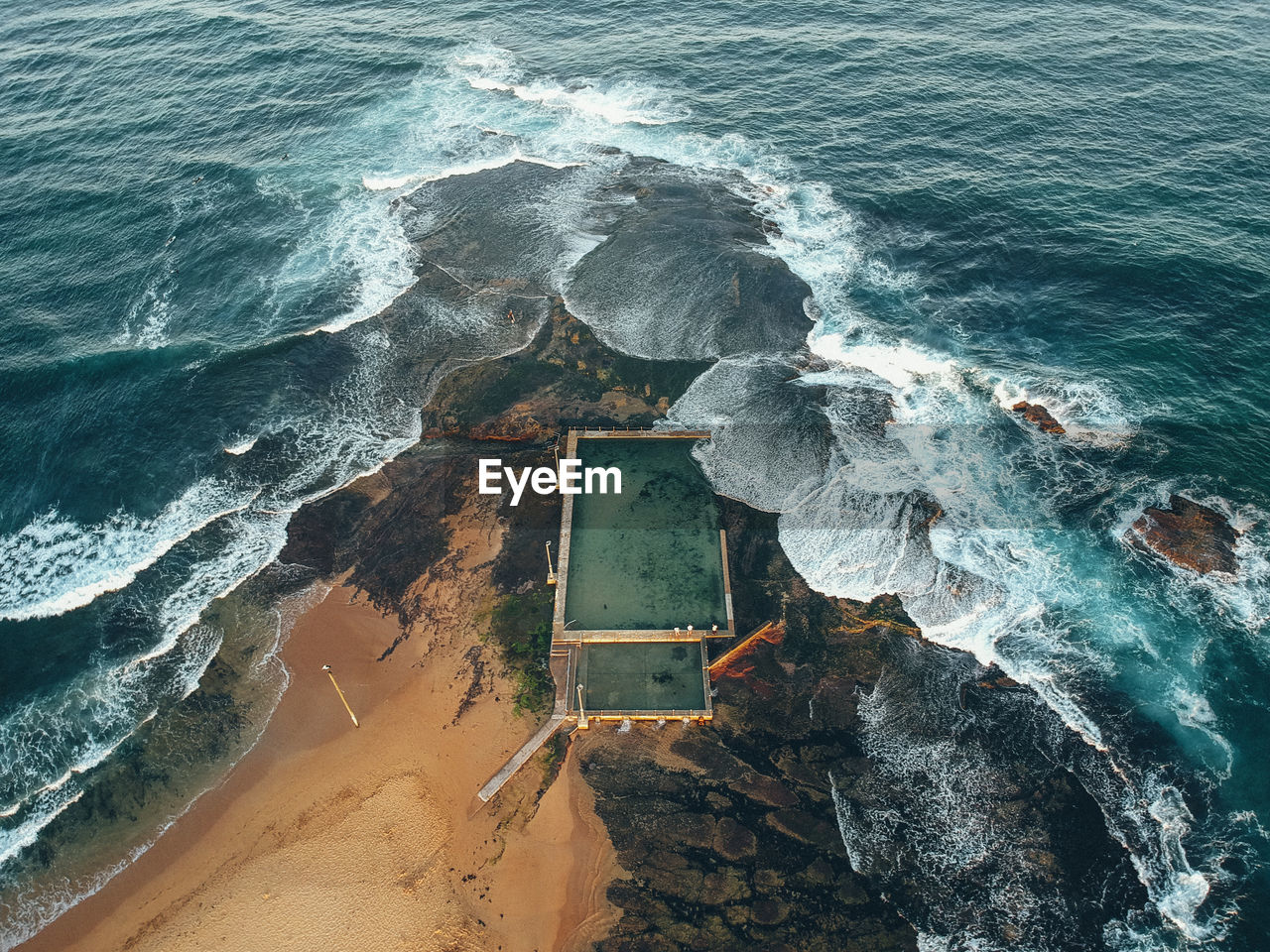 Aerial view of waves breaking on rocks