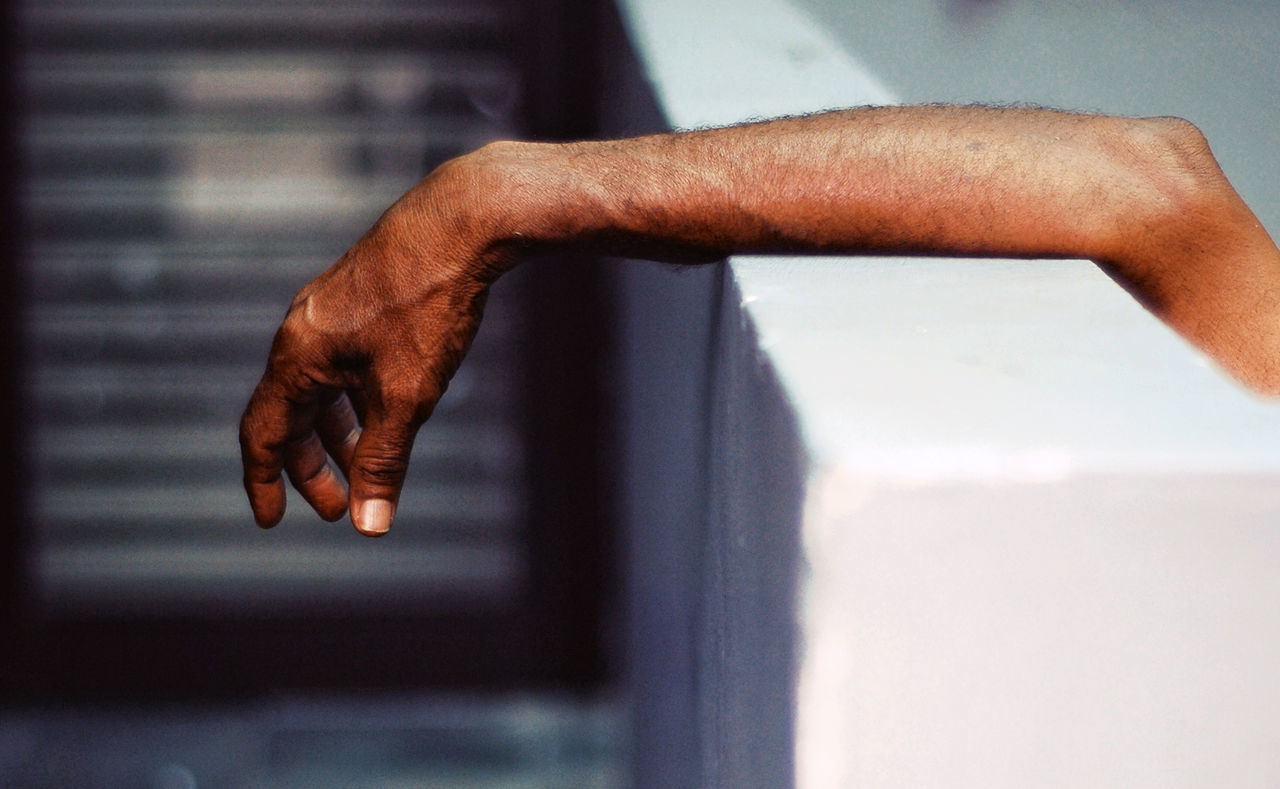 Close-up of hand on retaining wall