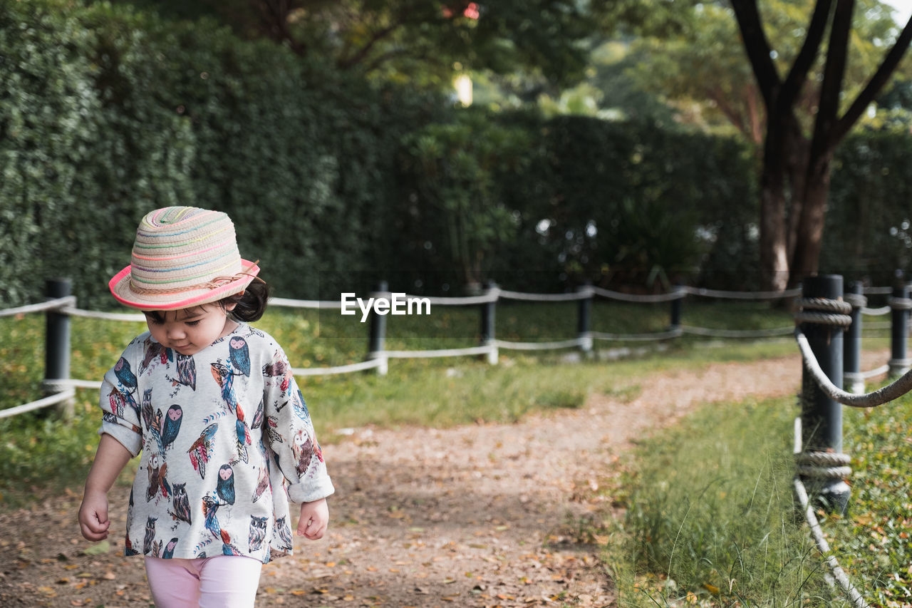 Cute girl walking on footpath at park