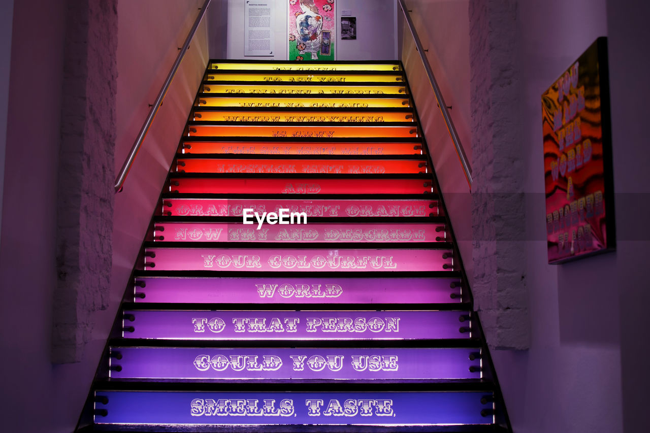 staircase, steps and staircases, architecture, stairs, interior design, text, indoors, light, communication, low angle view, built structure, no people, railing, western script, illuminated, the way forward, building