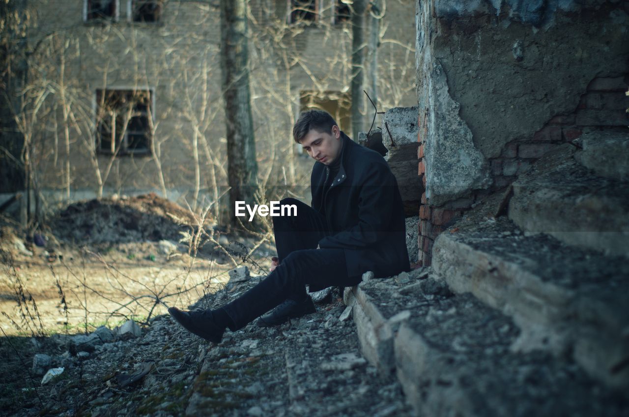 Young man sitting on rock