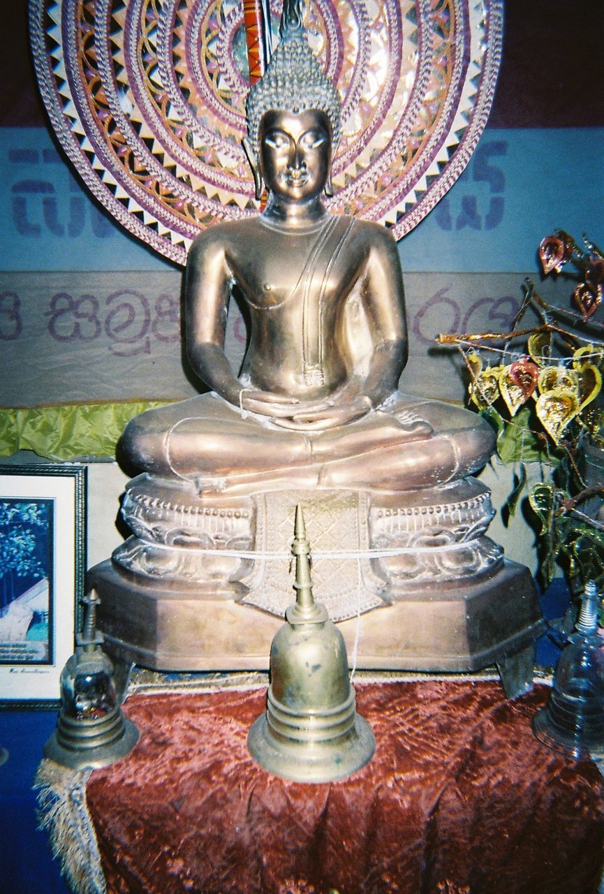 CLOSE-UP OF BUDDHA STATUE AGAINST WALL
