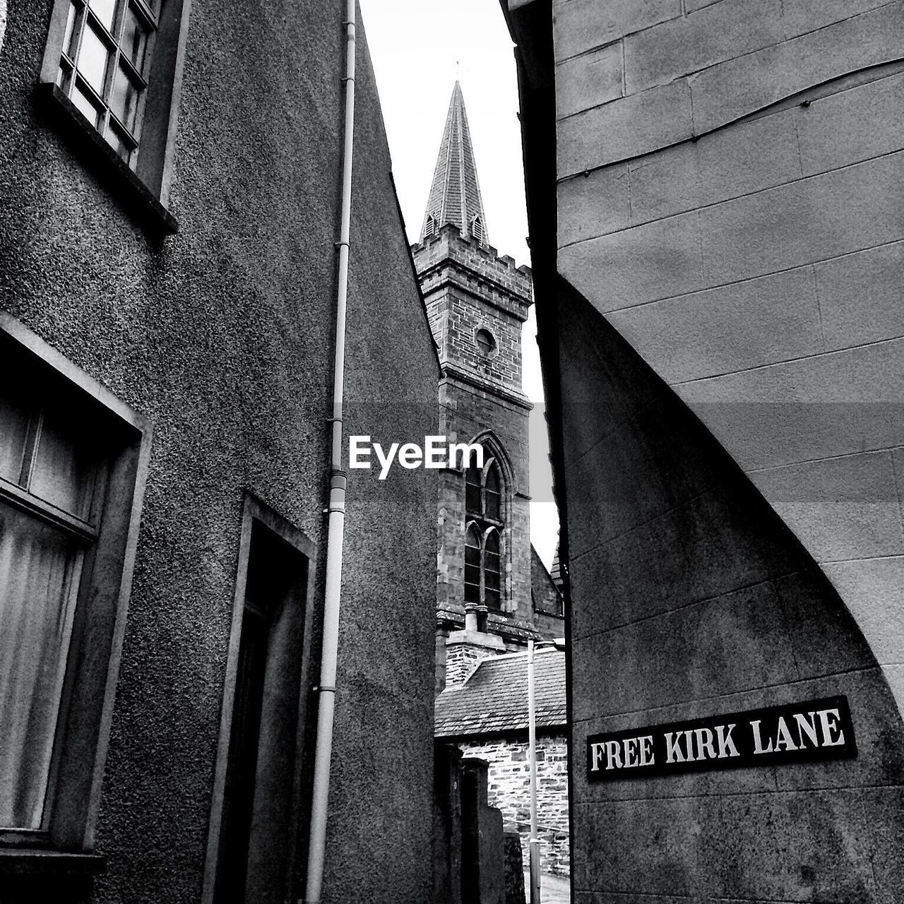 Low angle view of tower seen through buildings