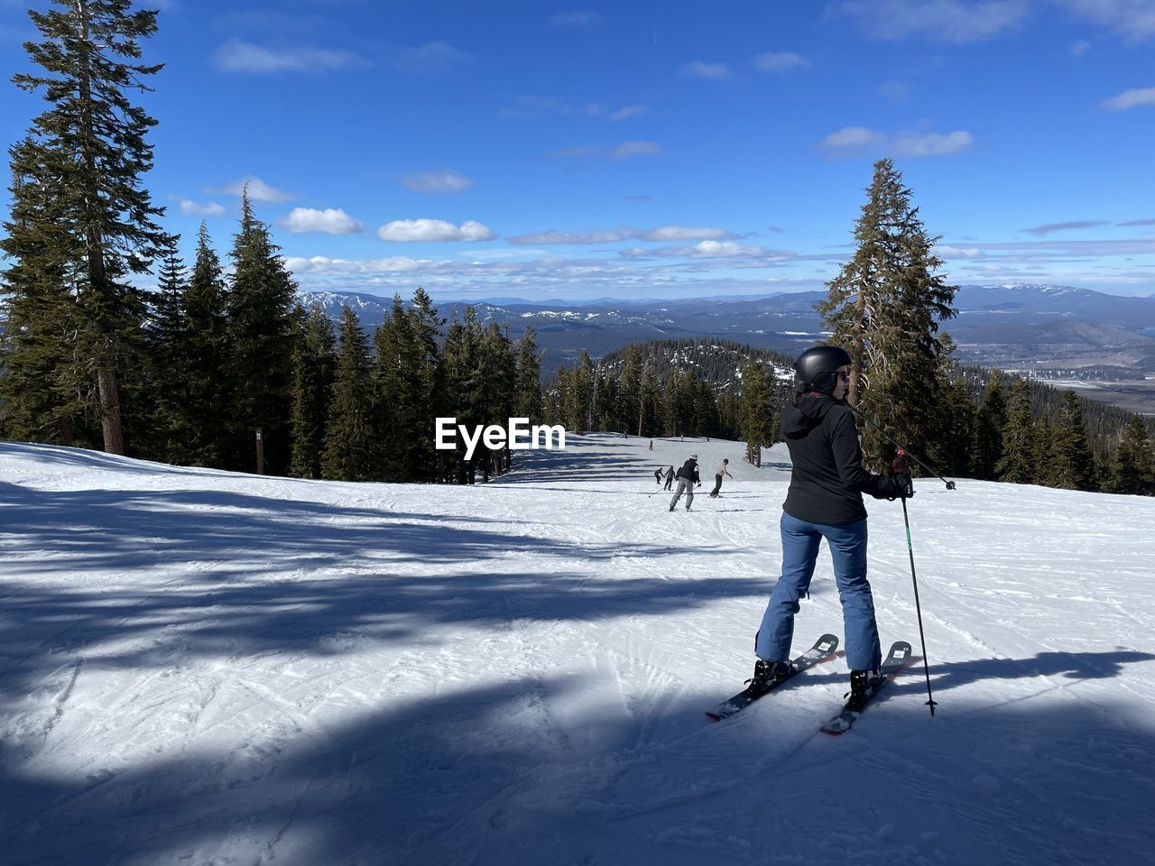 reflection, winter, blue, water, snow, nature, one person, sky, day, beauty in nature, lake, cold temperature, tree, mountain, cloud, wind, ice, scenics - nature, sunlight, environment, outdoors, skiing, plant, full length, men, adult, tranquility, leisure activity, non-urban scene, land, landscape