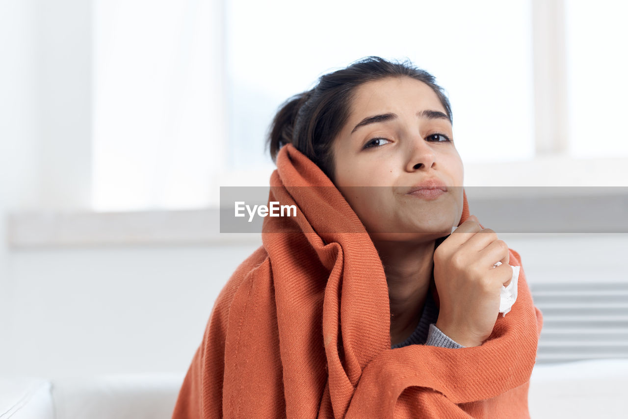 Portrait of young woman wrapped in blanket