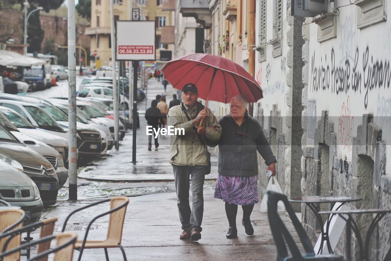 PEOPLE ON WET STREET IN CITY