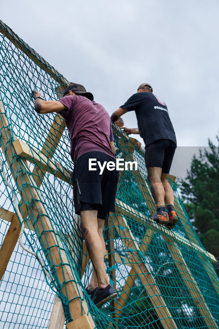 LOW ANGLE VIEW OF FRIENDS AGAINST THE SKY