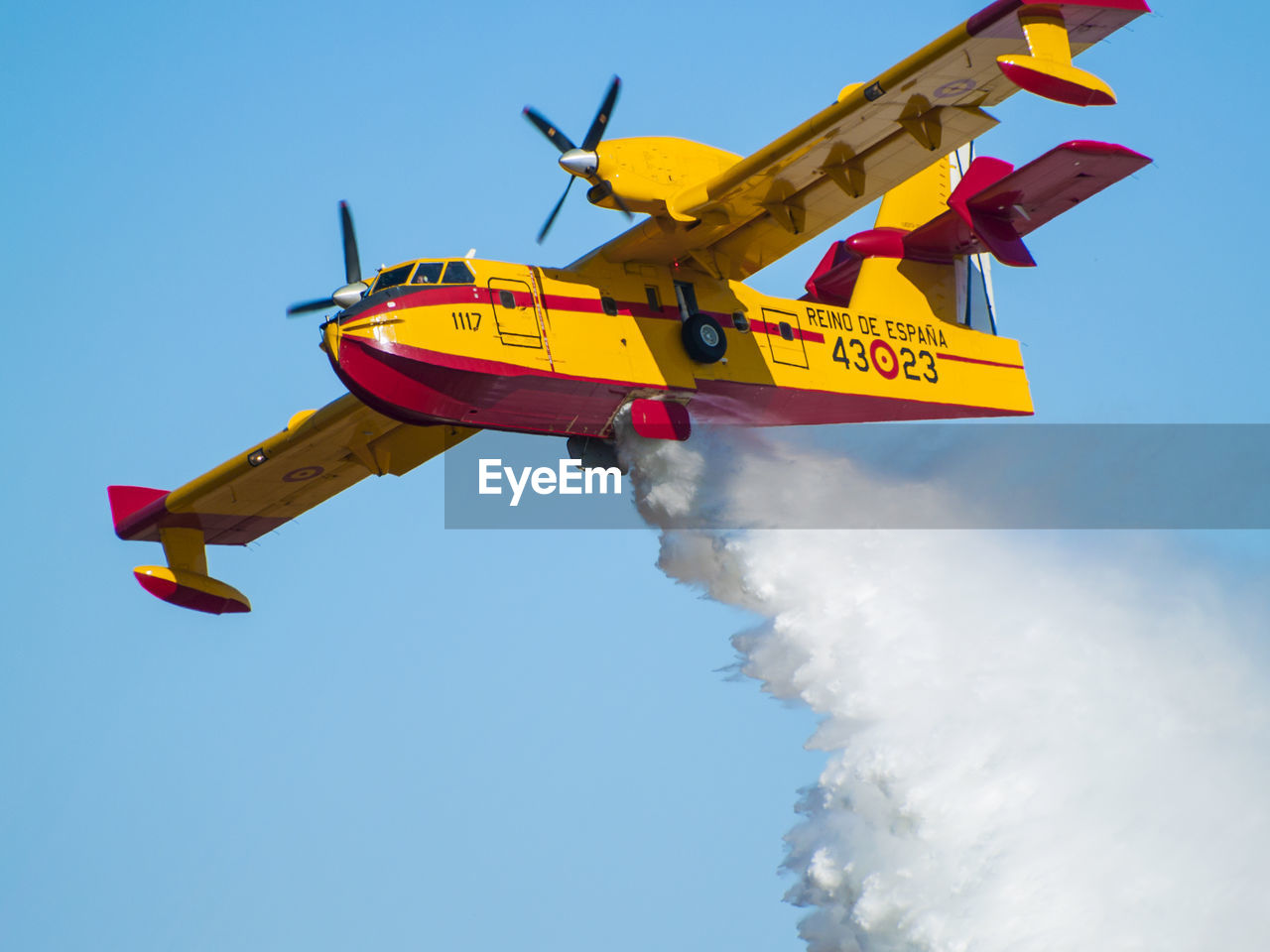 LOW ANGLE VIEW OF AIRPLANE FLYING AGAINST BLUE SKY