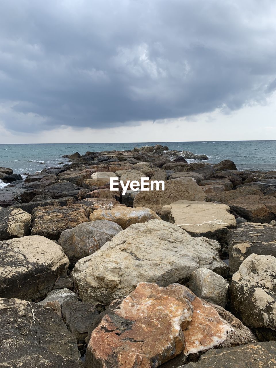 Rocks on sea shore against sky