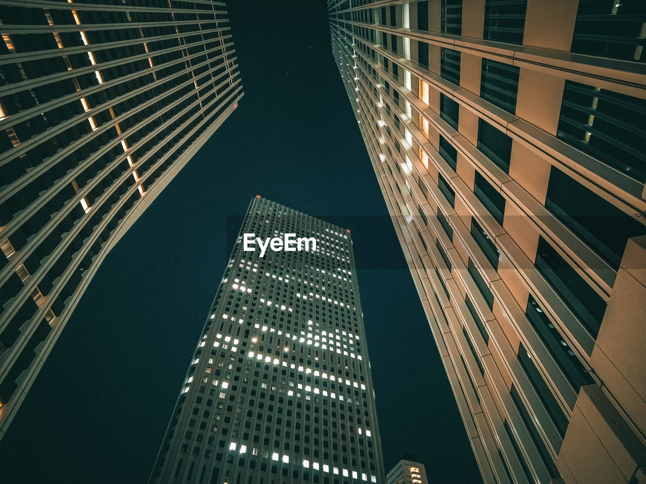 Some tall buildings in the city at night, in the style of low-angle