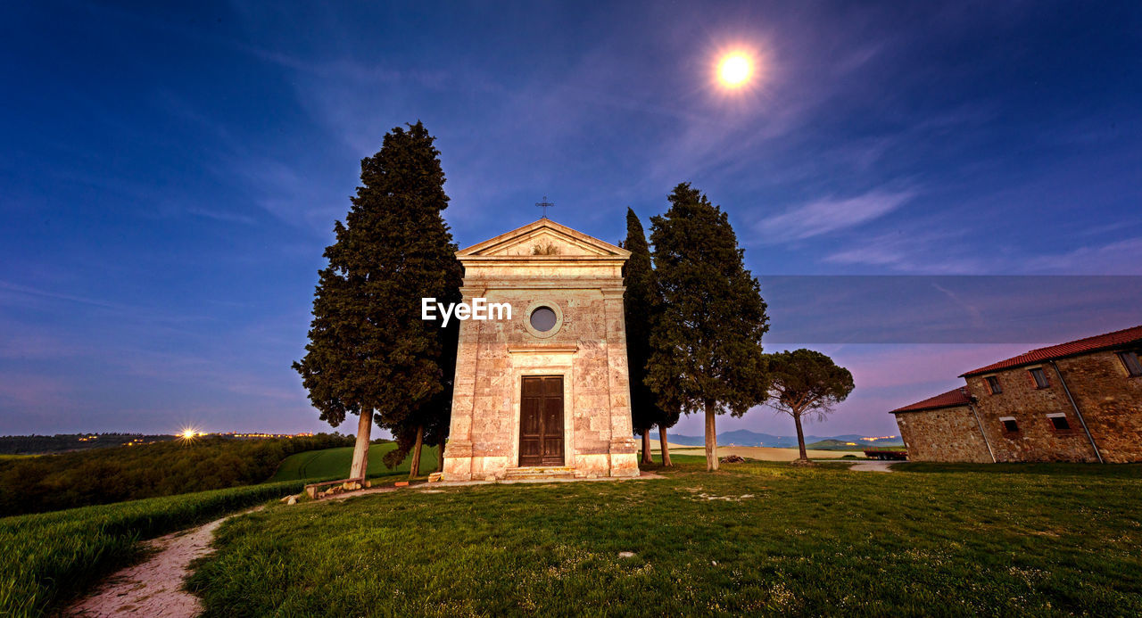 CHURCH ON FIELD AGAINST SKY