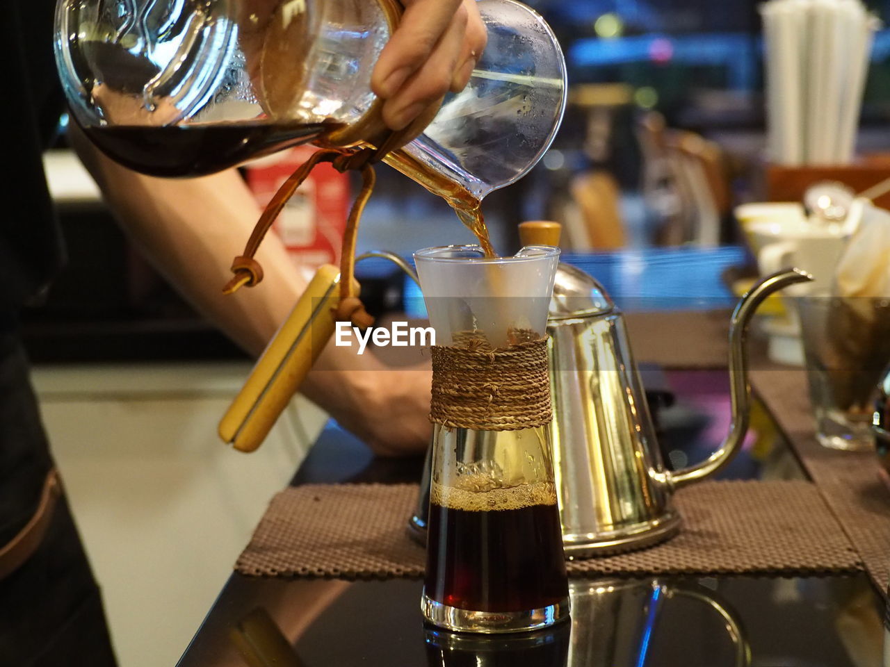 CLOSE-UP OF HAND POURING WINE IN GLASS