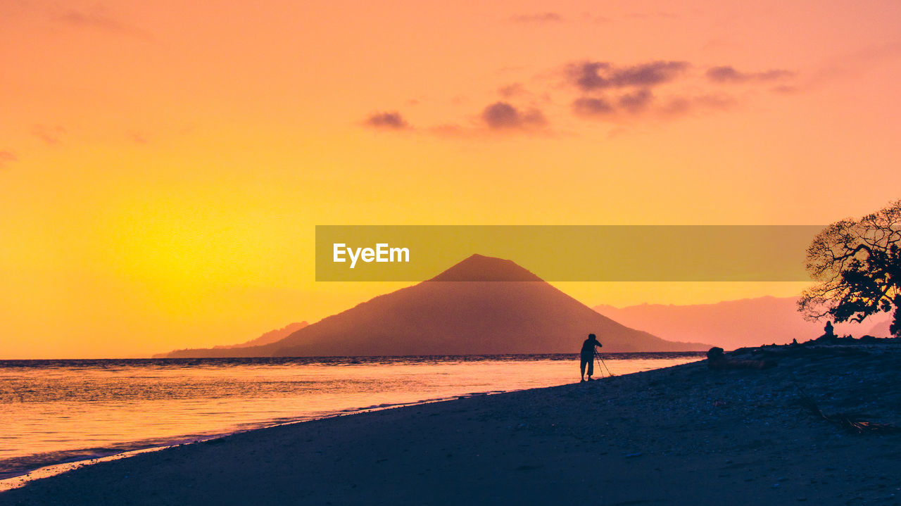 Scenic view of beach against orange sky