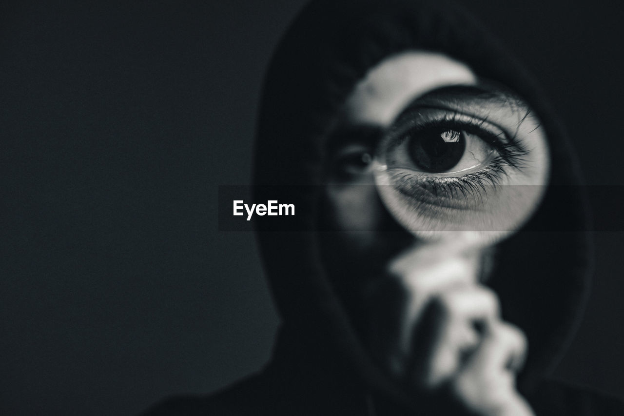 Close-up portrait of human eye against black background