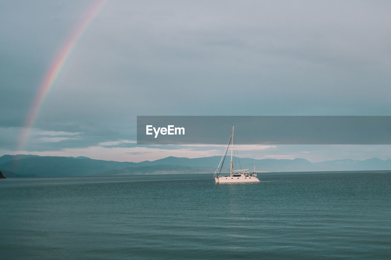 View of rainbow over sea and boat