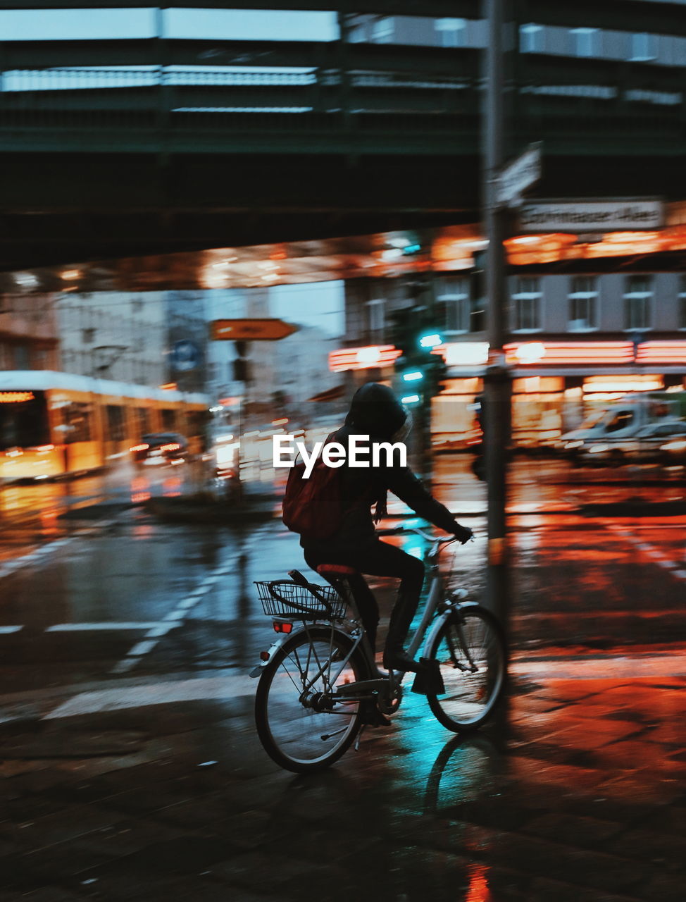 Person riding bicycle on road in city at night