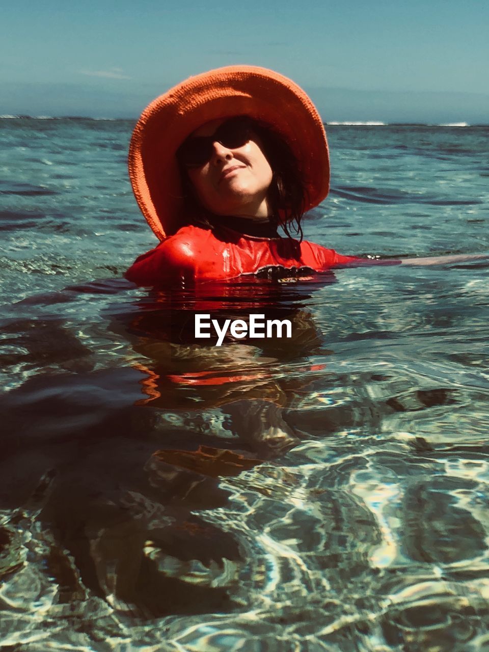 Woman wearing hat in sea against sky