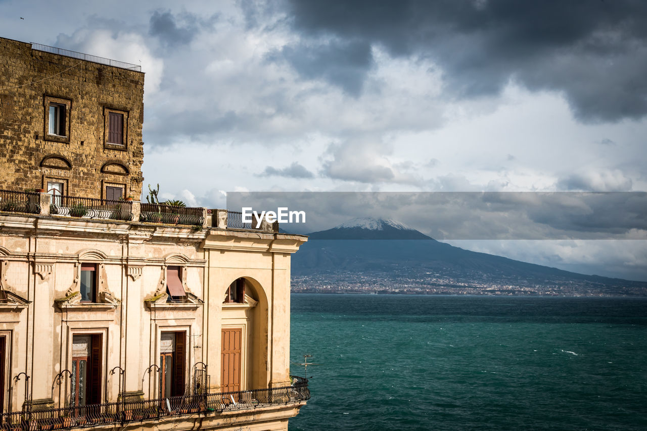 Built structure by sea against sky