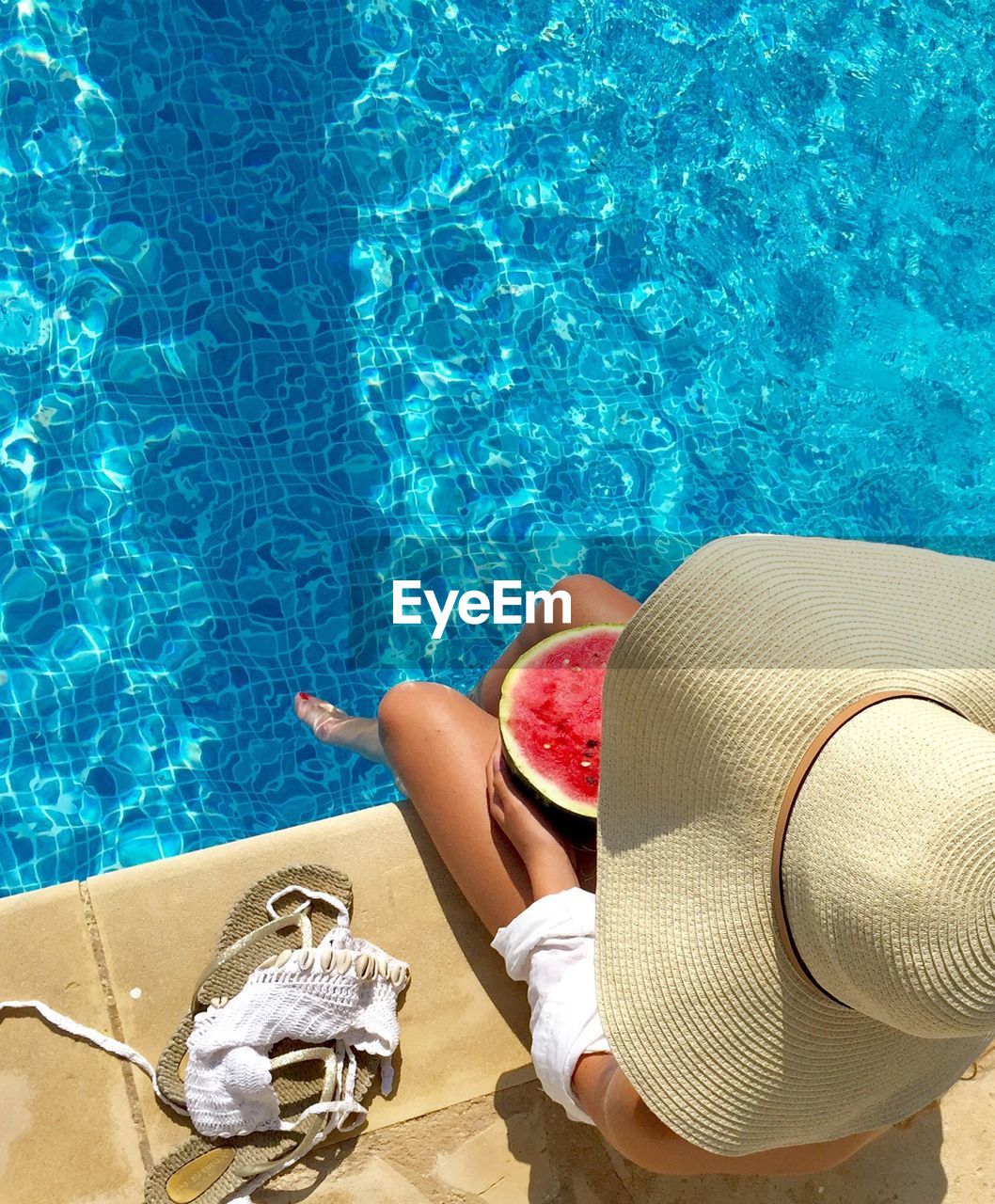 High angle view of woman sitting at poolside