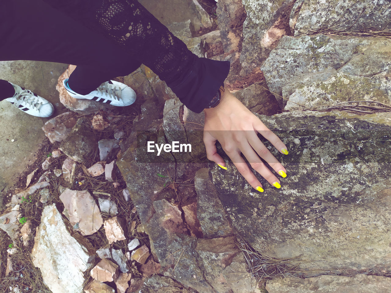 HIGH ANGLE VIEW OF HANDS ON ROCK