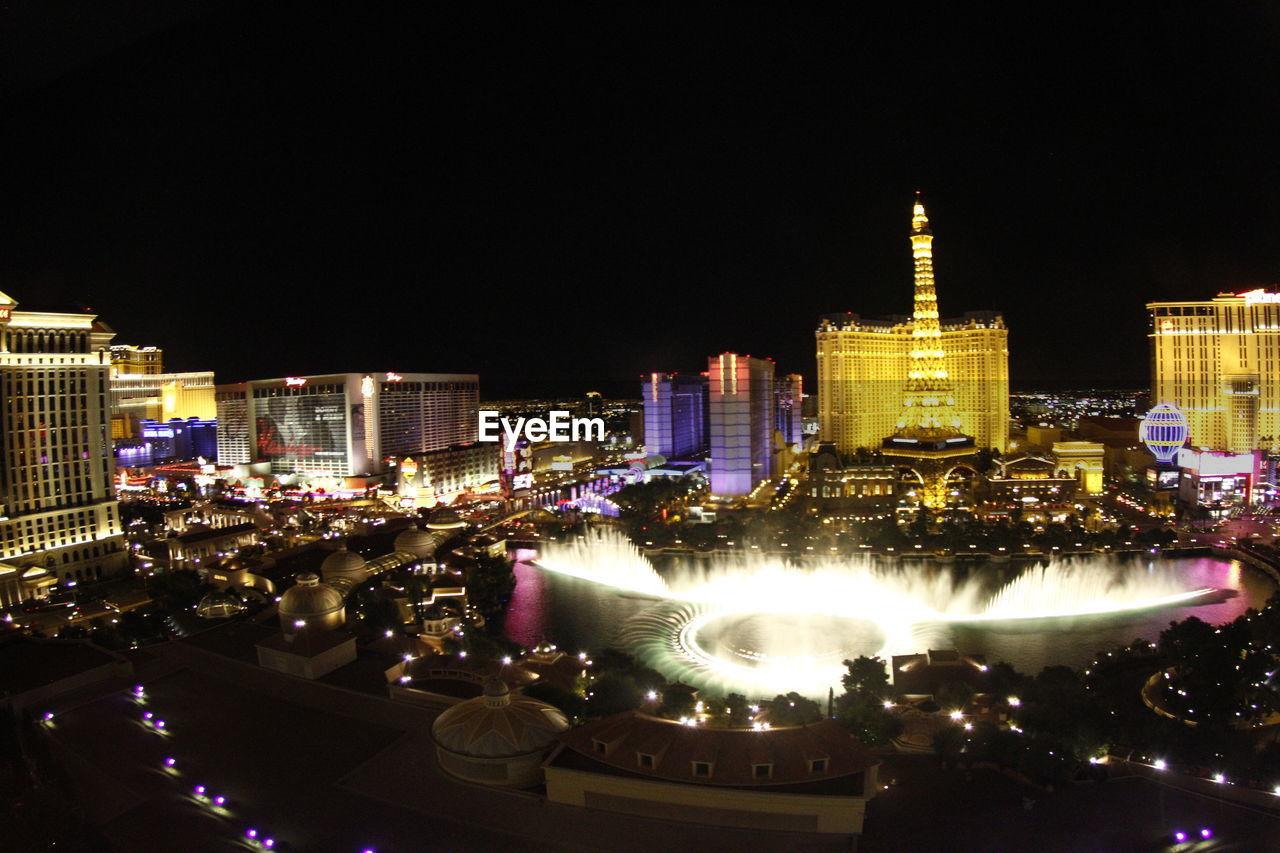 VIEW OF ILLUMINATED CITYSCAPE AT NIGHT