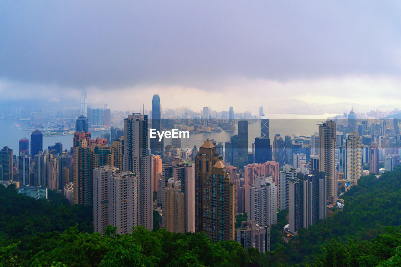 Modern buildings in city against cloudy sky